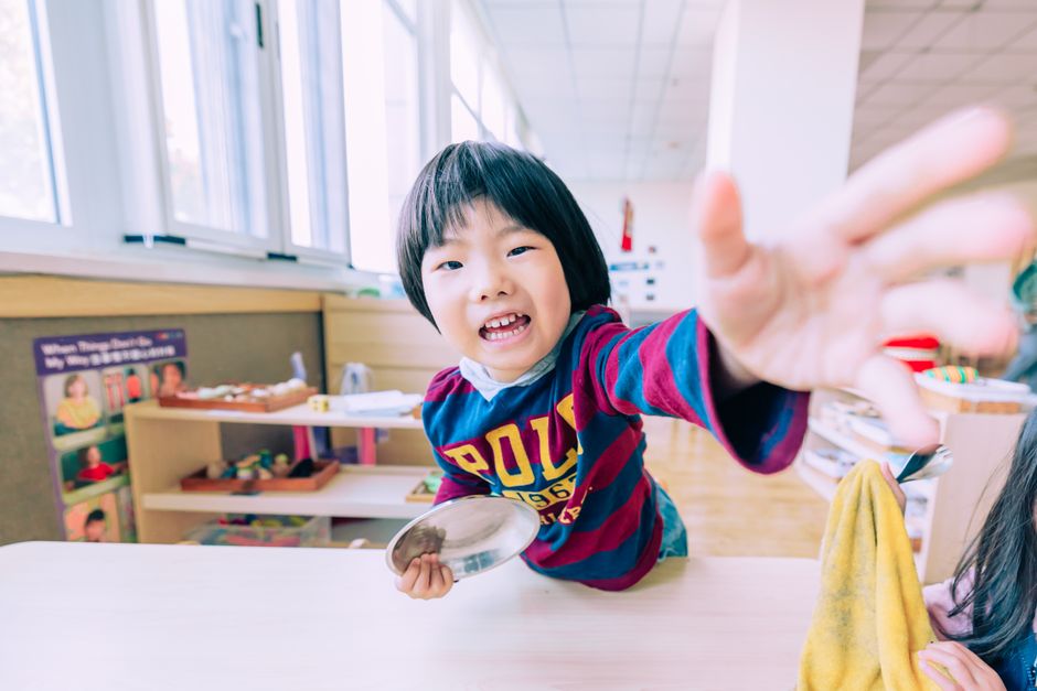 明るい教室でカメラに手を伸ばす楽しい子供、魅力的で遊び心あふれる雰囲気。