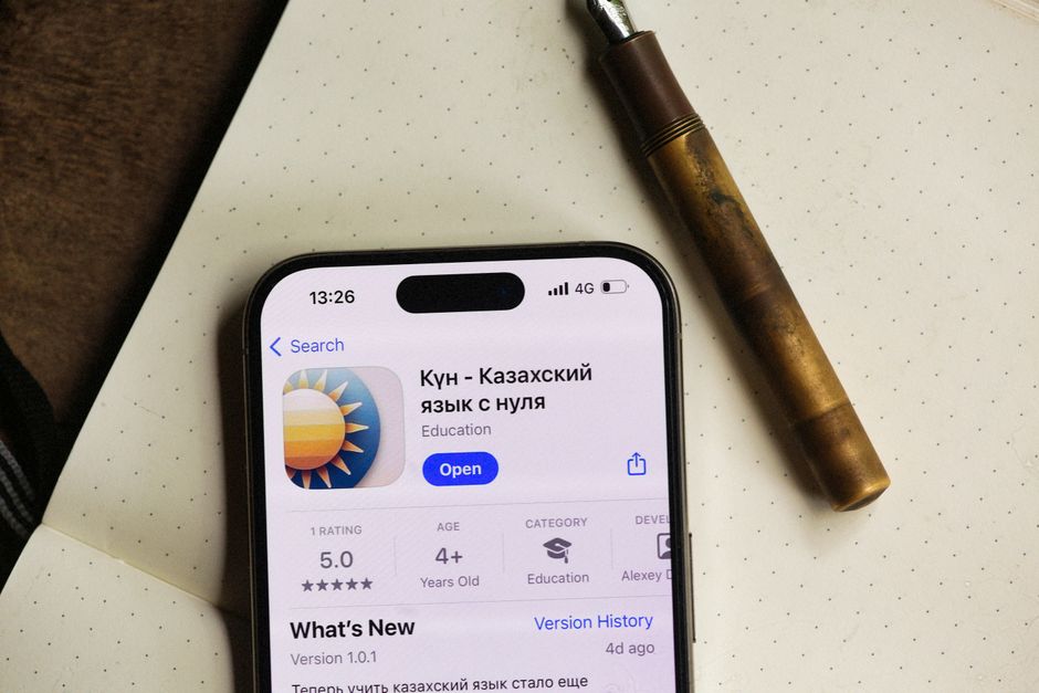 スマートフォンの画面には、点線の紙の上にペンで書かれた教育用アプリのインターフェースが表示されています。
